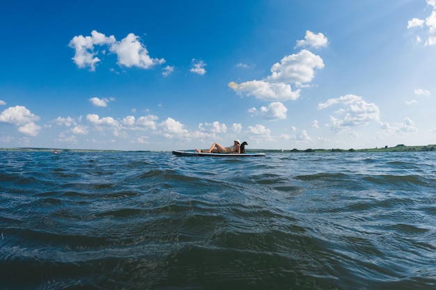 happy woman with dog on supboard summer vacation