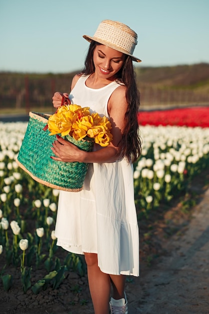 Happy woman with flowers walking near field