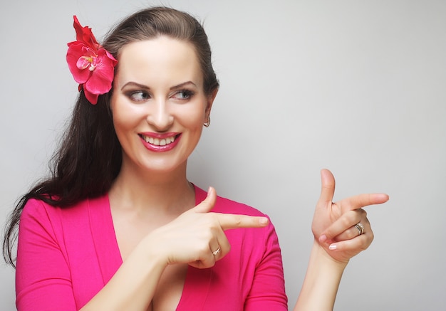 Happy woman with pink flower in the hair