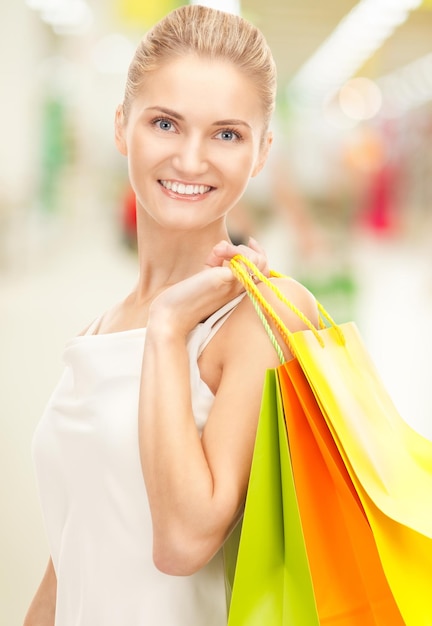 happy woman with shopping bags at the mall