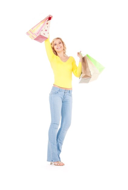 happy woman with shopping bags over white wall