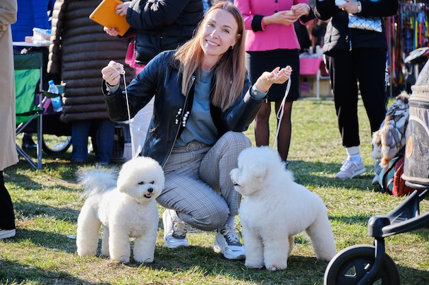 A happy woman with two beloved dogs of the Bichon Frise breed