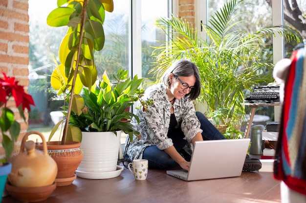 Happy woman working at home Smiling adult person using laptop on garden terrace