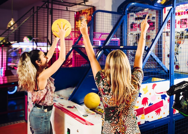 Happy women playing basketball arcade game