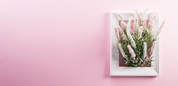 Happy Women's Day decoration concept made from flower and picture frame on pink pastel background