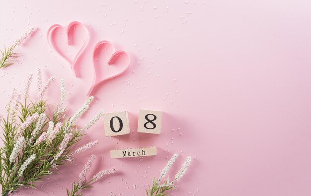 Photo happy womens day decoration concept made from flower paper heart and wooden calendar on pink pastel background