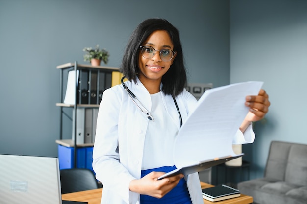 Happy young african female nurse working in office