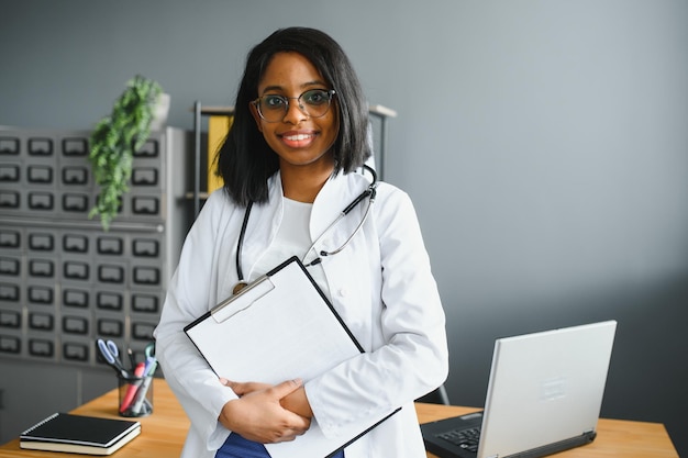 Happy young african female nurse working in office