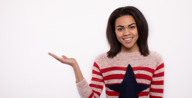 Happy Young African Woman Presenting On White wall