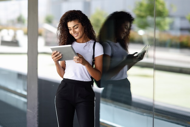 Happy young Arab woman using digital tablet in business. 