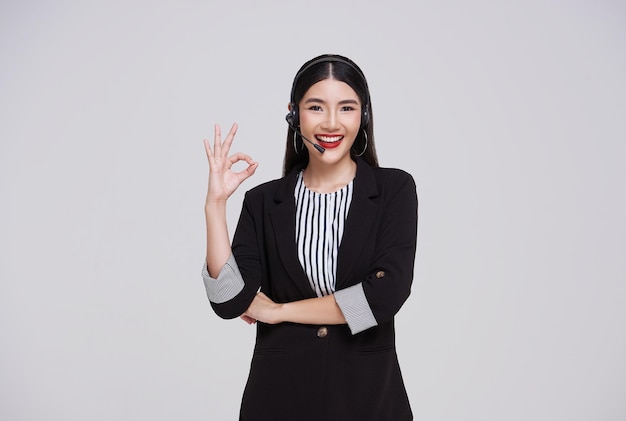 Happy young asian business woman call centre showing OK sign Welcome female operator