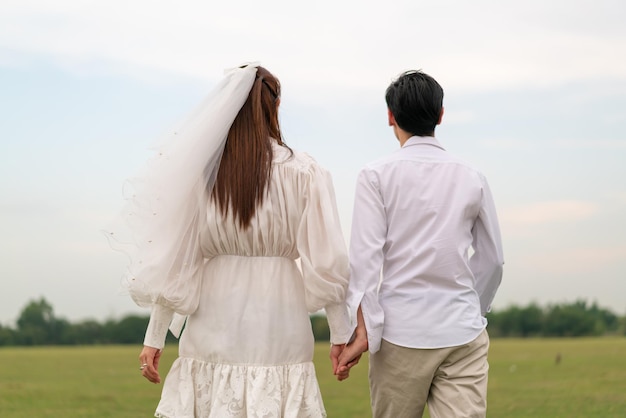 Happy young Asian couple in bride and groom clothing