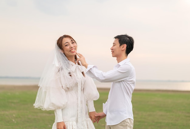 Happy young Asian couple in bride and groom clothing