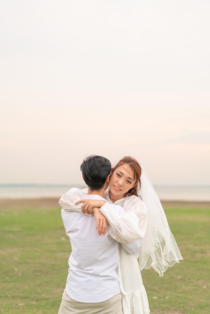 Happy young Asian couple in bride and groom clothing