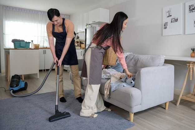 Happy young Asian couple cleaning home together healthy lifestyle concept