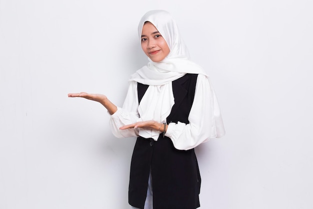 Happy young asian muslim business woman pointing with fingers to different directions  on white