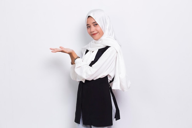 Happy young asian muslim business woman pointing with fingers to different directions  on white