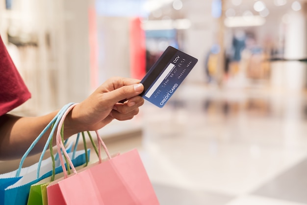 Happy young asian woman holding credit card and colorful shopping bags, Woman lifestyle concept	