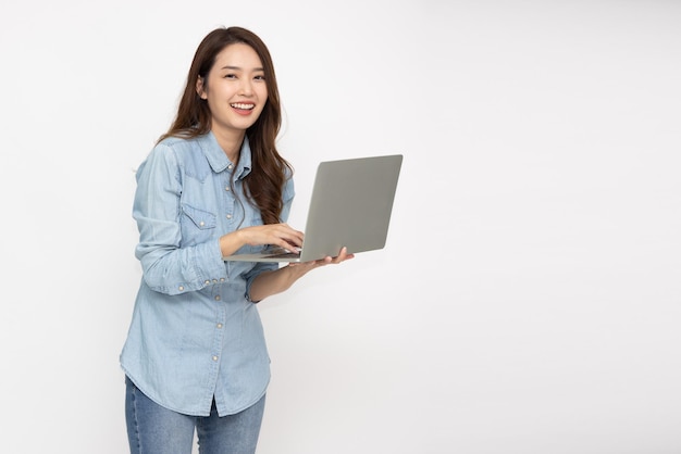 Happy young Asian woman holding laptop computer isolated over white background and Looking at camera