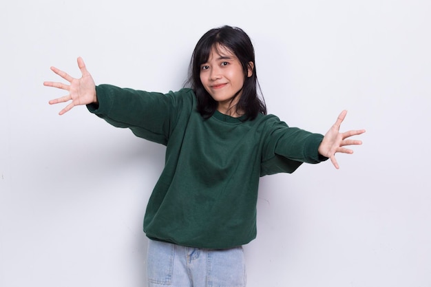 Happy young asian woman pointing with fingers to different directions isolated on white background