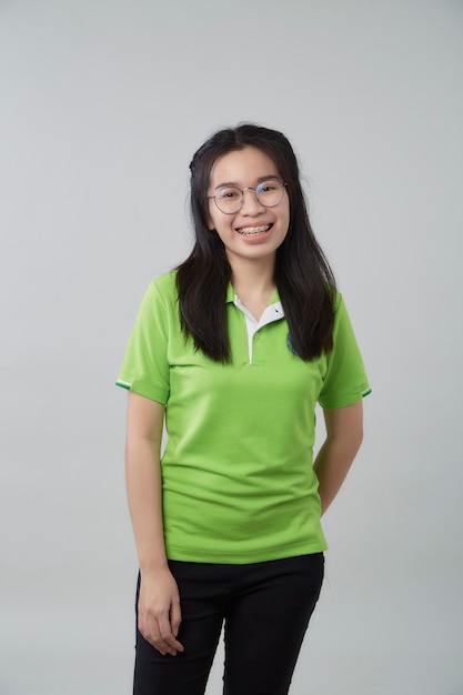 Happy young Asian woman portrait with a green shirt gray background, beautiful Asian confidence teenager