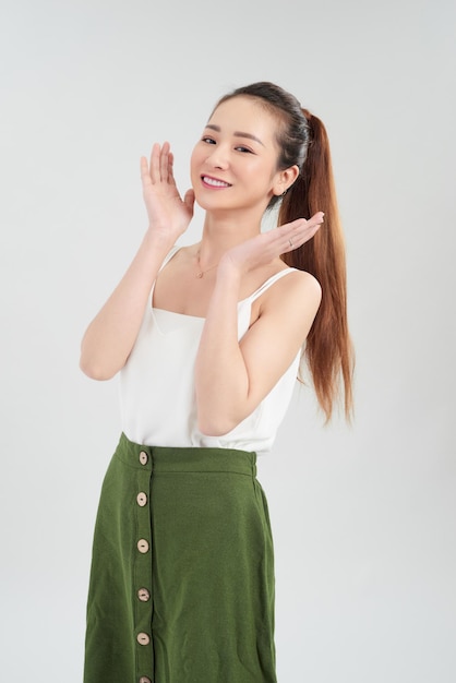 Happy young Asian woman standing over white background