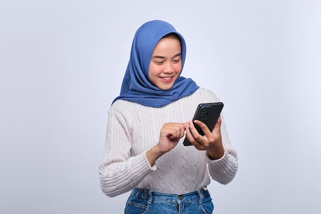 Happy young Asian woman using smartphone for messaging with a friend isolated on white background