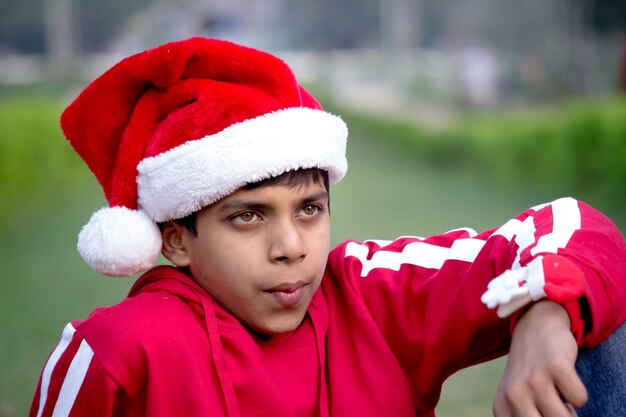 A happy young attractive smiling boy in Santa cap,  Looking at a distance    
