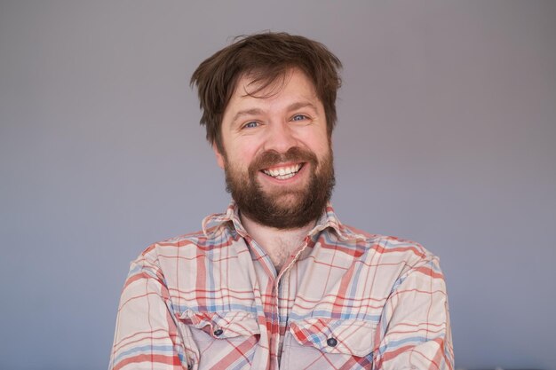 Happy young bearded guy looking at camera brightfully smiling with teeth