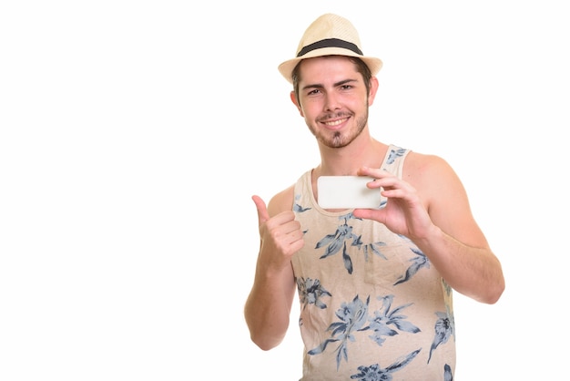 Happy young bearded tourist man taking picture with phone ready for vacation