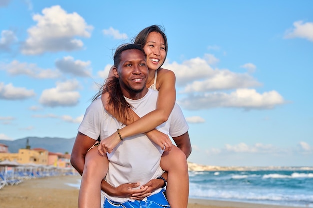 Happy young beautiful couple having fun on the beach