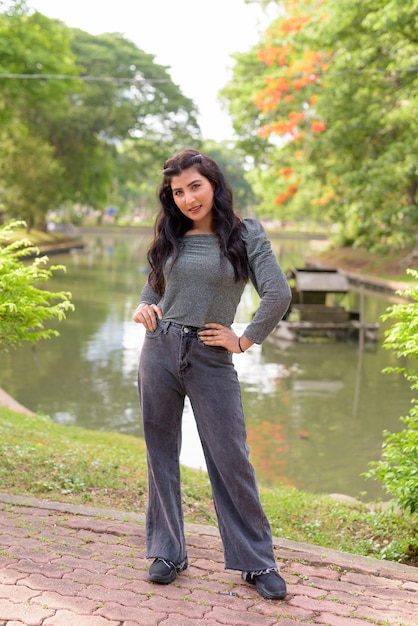 happy young beautiful Indian woman smiling at the park outdoors