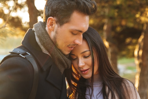 happy young beautiful loving couple posing walking hugging outdoors in park nature.