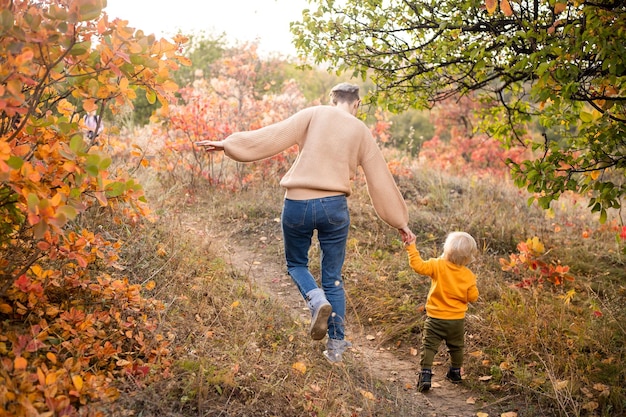 Happy young beautiful mother with her little son in the park