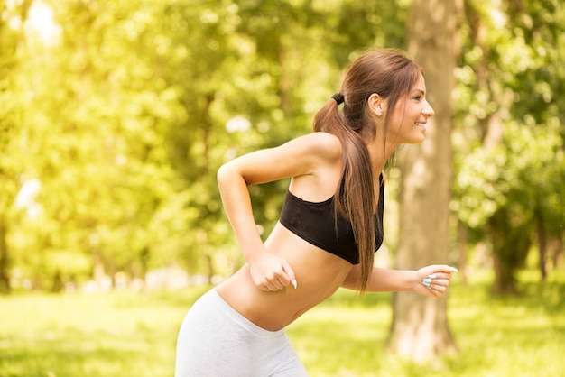 Happy young beautiful woman running in the park