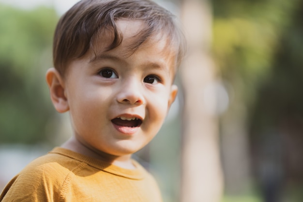 Happy young boy playing outdoors in the park