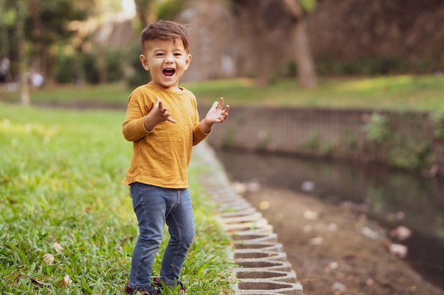 Happy young boy playing outdoors in the park