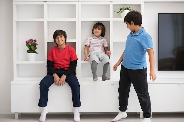 happy young boys are having fun while posing on a shelf in a new modern home