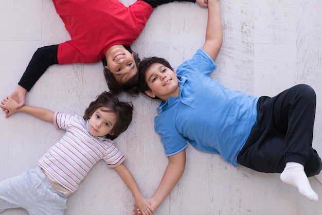 happy young boys having fun on the floor in a new modern home