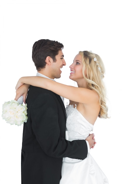 Happy young bridegroom hugging his wife 