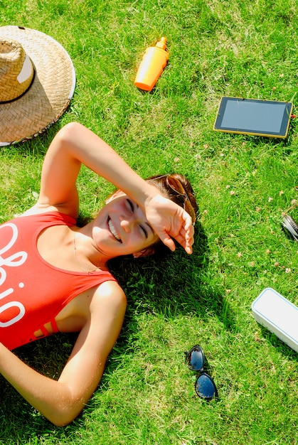 Happy young brunette woman listening to the music outdoor on a summer day