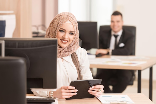 Happy Young Business Man And Muslim Woman Work In Modern Office On Computer