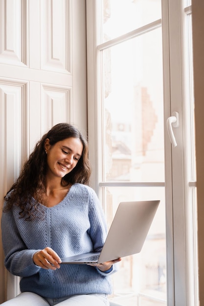 Happy young business woman is chatting with colleagues and have video conference Girl blogger with laptop is chatting online with her subscribers via video connection