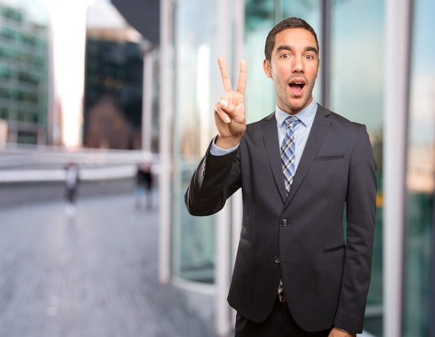 Happy young businessman doing a victory gesture