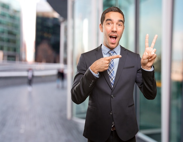 Happy young businessman doing a victory gesture