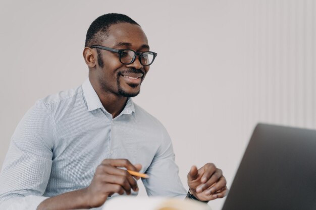 Happy young businessman in formal wear has video chat with client or colleagues in zoom