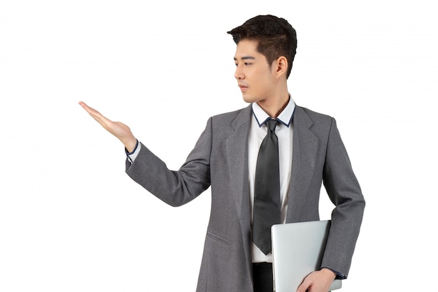 Happy young businessman looking hand and hold laptop in suit, isolated concept