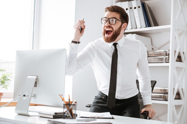 Happy young businessman make winner gesture.