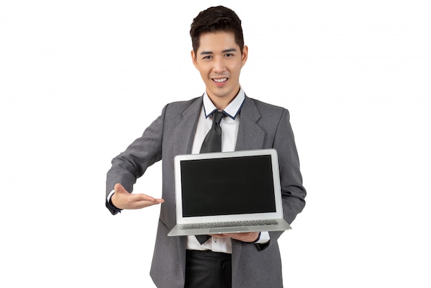 Happy young businessman show laptop in suit looking at camera, isolated concept