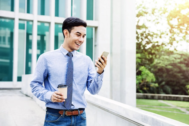 Happy Young Businessman using a Smart Phone outdoor